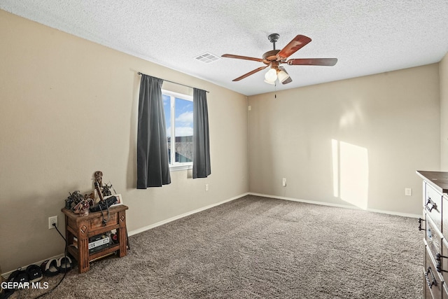 carpeted spare room featuring ceiling fan and a textured ceiling