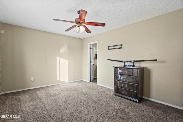 unfurnished bedroom with ceiling fan, dark carpet, and a textured ceiling