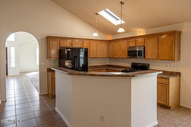 kitchen featuring stove, pendant lighting, a kitchen island, and black fridge