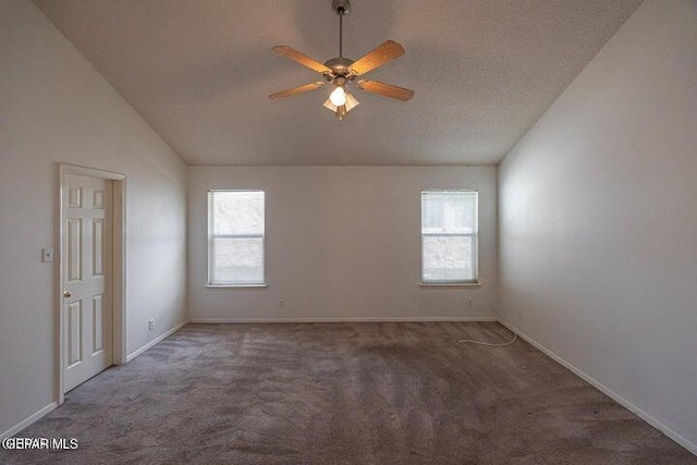 empty room with vaulted ceiling, ceiling fan, and dark carpet