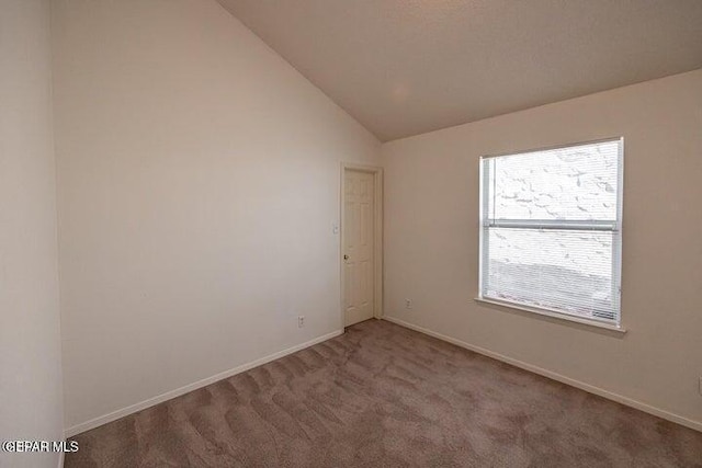 unfurnished room featuring lofted ceiling and carpet flooring