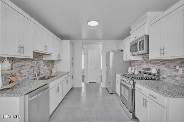 kitchen with white cabinetry, sink, stainless steel appliances, and light stone countertops