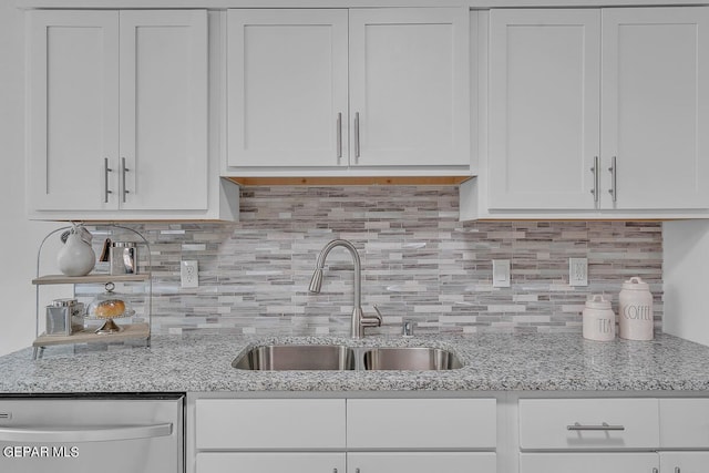 kitchen featuring white cabinetry, sink, light stone counters, and stainless steel dishwasher