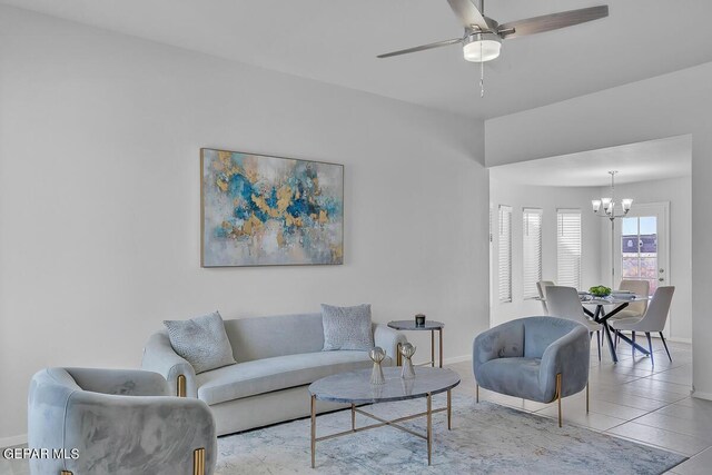 living room with ceiling fan with notable chandelier and light tile patterned floors