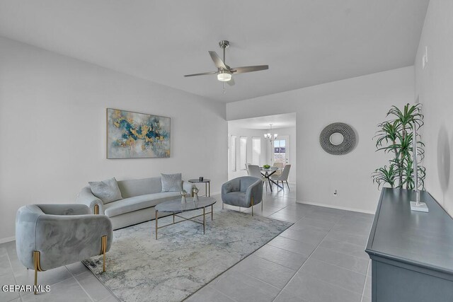 living room with tile patterned flooring and ceiling fan with notable chandelier