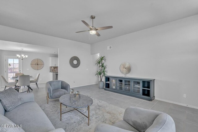 living room featuring ceiling fan with notable chandelier and light tile patterned floors