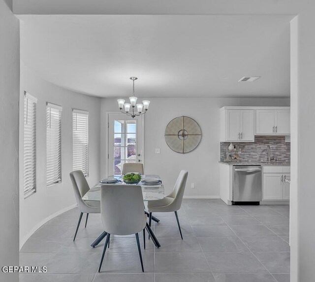 dining room featuring sink, a notable chandelier, and light tile patterned floors