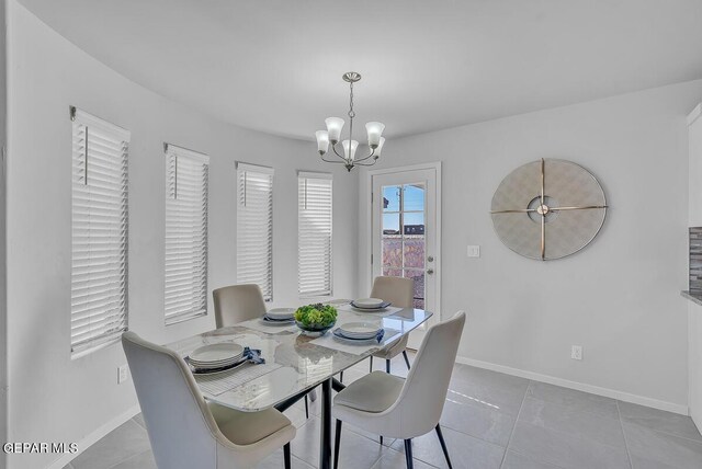 tiled dining room featuring a notable chandelier