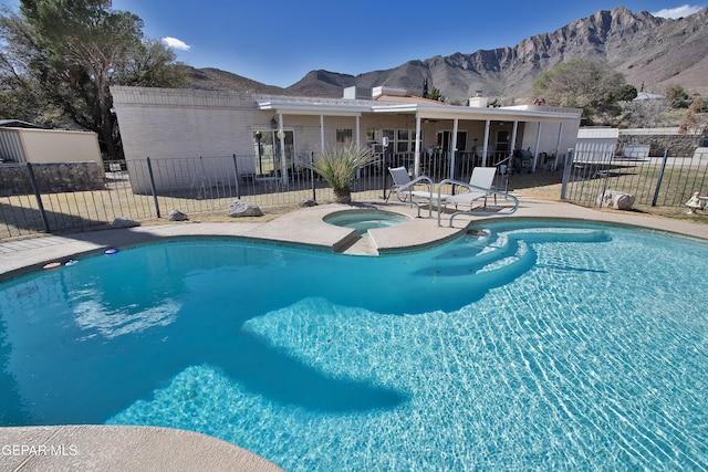 view of pool featuring an in ground hot tub, a mountain view, and a patio