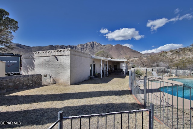 exterior space with a fenced in pool, a mountain view, and a patio