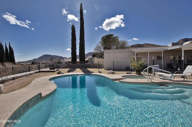 view of pool with an in ground hot tub and a mountain view