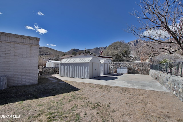 view of yard with a mountain view, a patio area, and a storage shed