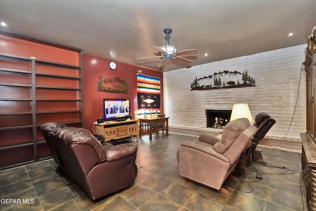 living room featuring ceiling fan, brick wall, and a fireplace