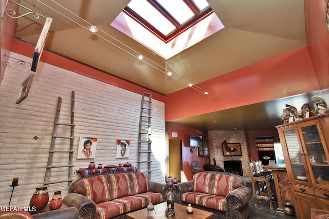 living room featuring brick wall, a fireplace, and a skylight