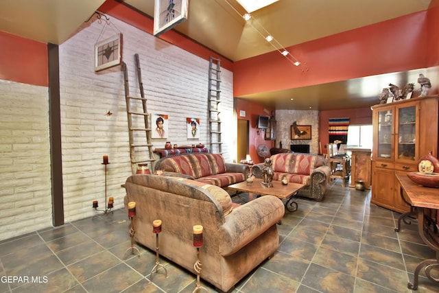 living room featuring brick wall and dark tile patterned flooring