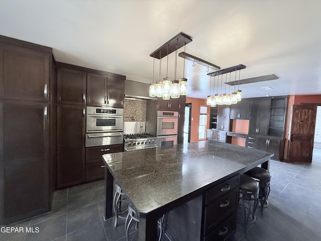 8204 Big Bend Dr, El Paso, TX 79904 - kitchen with a breakfast bar area, a warming drawer, high end stainless steel range, dark tile patterned floors, and dark brown cabinetry
