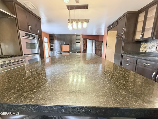 8204 Big Bend Dr, El Paso, TX 79904 - kitchen with open shelves, stainless steel double oven, dark brown cabinetry, tasteful backsplash, and glass insert cabinets