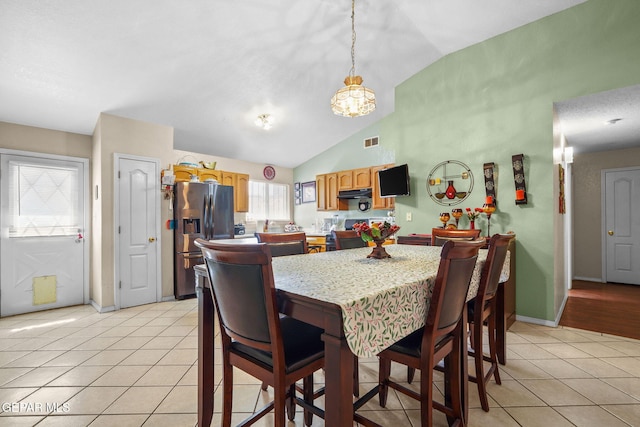 dining space featuring lofted ceiling and light tile patterned floors