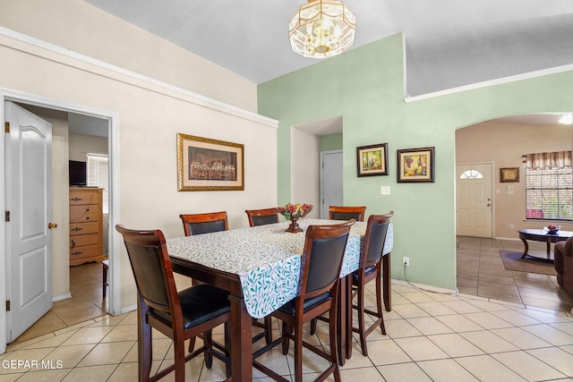 dining space featuring light tile patterned floors and a notable chandelier