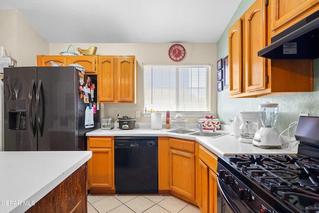 kitchen with sink, light tile patterned floors, and black appliances