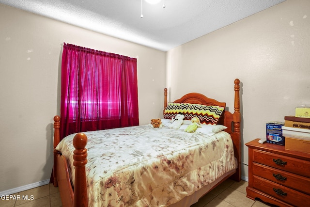 bedroom with light tile patterned floors, a textured ceiling, and ceiling fan