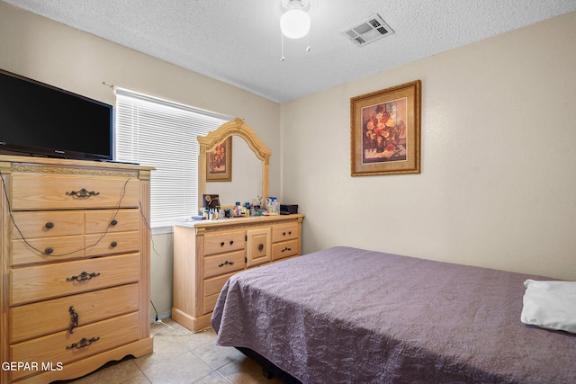 bedroom featuring light tile patterned floors, a textured ceiling, and ceiling fan