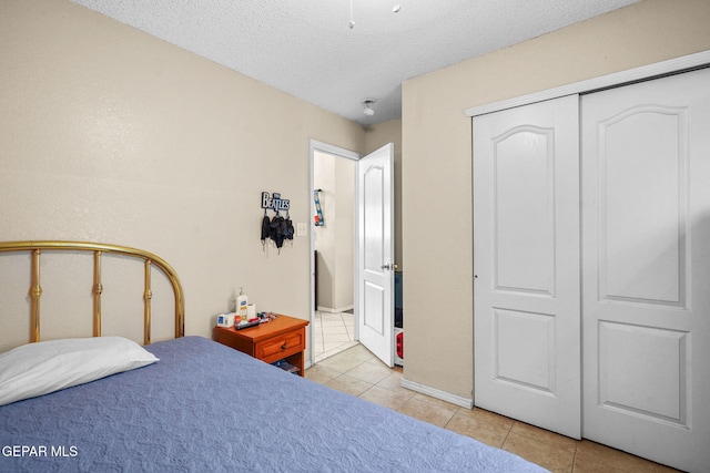 tiled bedroom featuring a closet and a textured ceiling