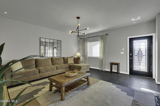 living room featuring an inviting chandelier and dark tile patterned floors