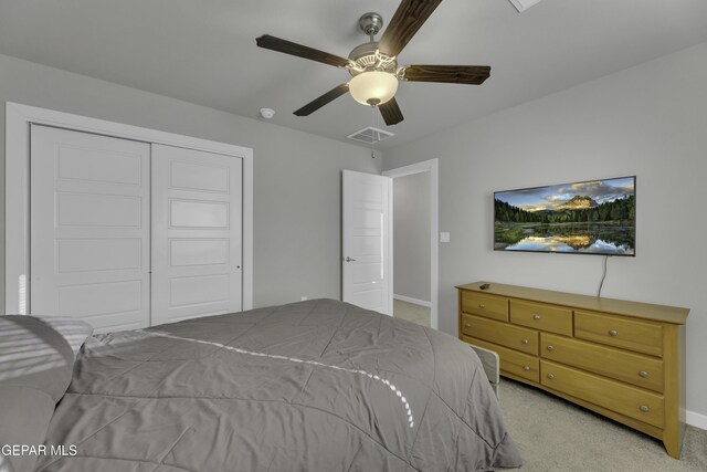 bedroom featuring light colored carpet, a closet, and ceiling fan