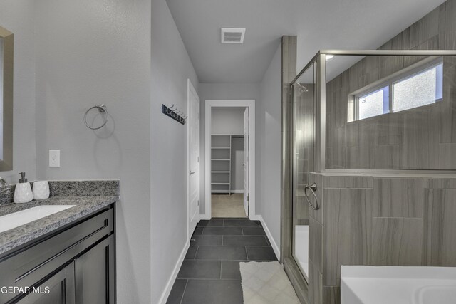 bathroom featuring vanity, tile patterned flooring, and walk in shower