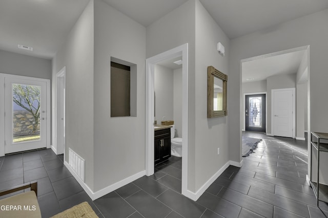 hall featuring dark tile patterned floors