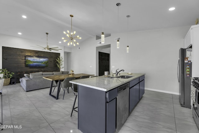 kitchen with sink, appliances with stainless steel finishes, vaulted ceiling with beams, hanging light fixtures, and a center island with sink