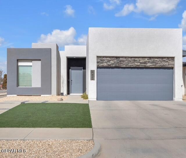 453 Plateau Dr, Socorro, TX 79927 - contemporary house featuring stucco siding, driveway, and a garage