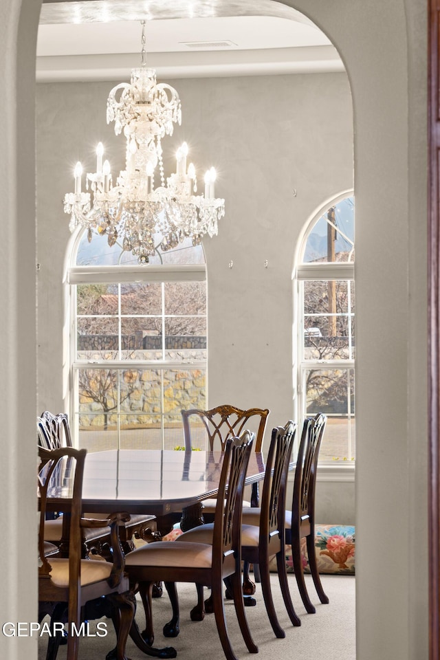 dining area with plenty of natural light, carpet flooring, and a chandelier