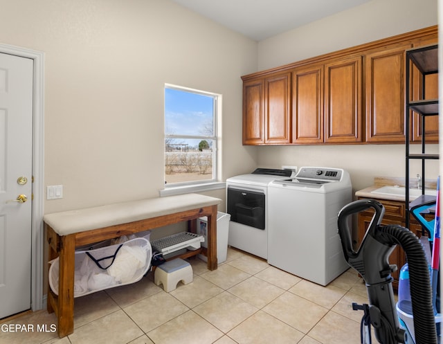 laundry room with cabinets, washer and dryer, and light tile patterned floors