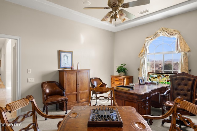 sitting room featuring ceiling fan, a tray ceiling, and light tile patterned floors