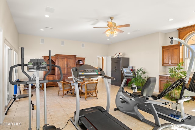 workout room featuring light tile patterned floors and ceiling fan