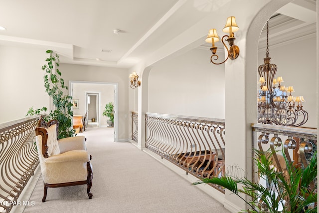 hall featuring carpet and a notable chandelier