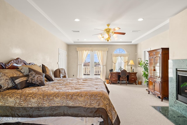 bedroom featuring carpet, a high end fireplace, ceiling fan, and a tray ceiling