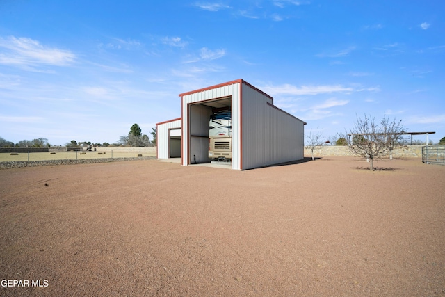 view of outdoor structure with a garage and a rural view