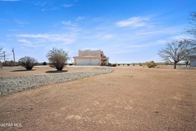 view of yard featuring a rural view and a garage