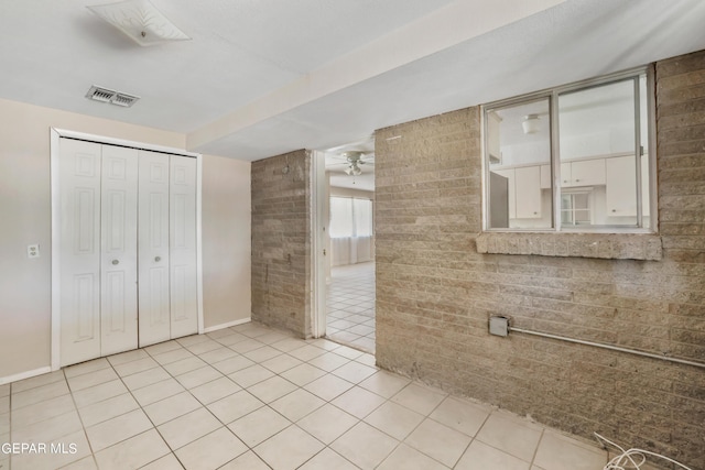 bathroom with tile patterned flooring, brick wall, and ceiling fan