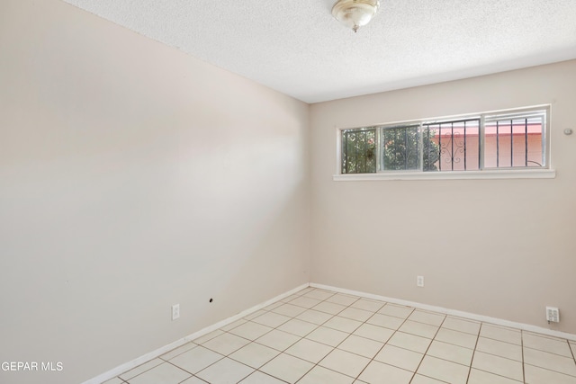 tiled empty room with a textured ceiling