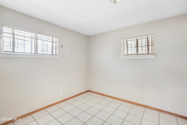 tiled spare room with a healthy amount of sunlight