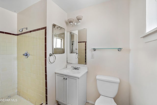 bathroom with vanity, toilet, and tiled shower