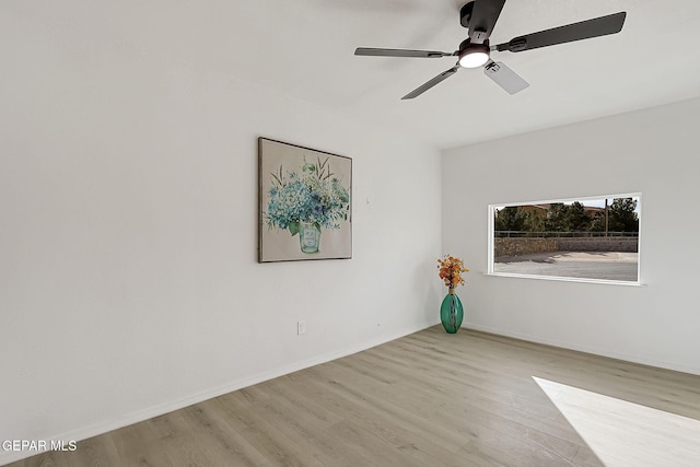 empty room with ceiling fan and light hardwood / wood-style flooring