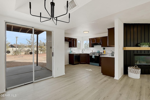 kitchen with sink, light hardwood / wood-style floors, stainless steel appliances, dark brown cabinets, and an inviting chandelier