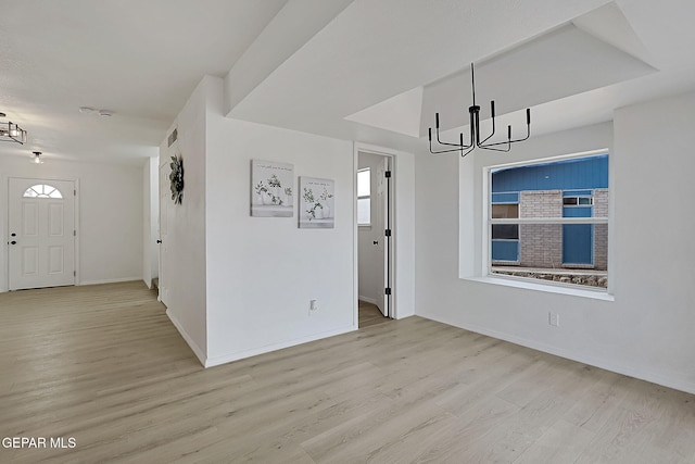 unfurnished dining area with a chandelier and light hardwood / wood-style floors