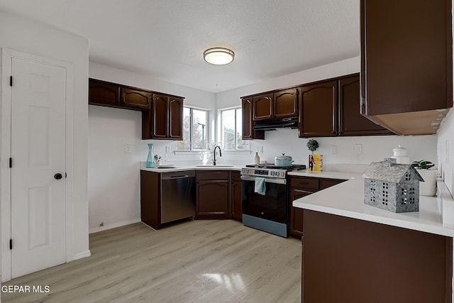 kitchen featuring dark brown cabinetry, sink, stainless steel appliances, and light wood-type flooring