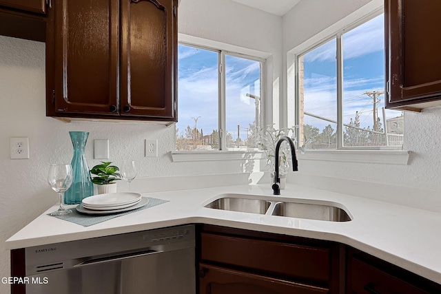 kitchen with sink, dark brown cabinets, and stainless steel dishwasher